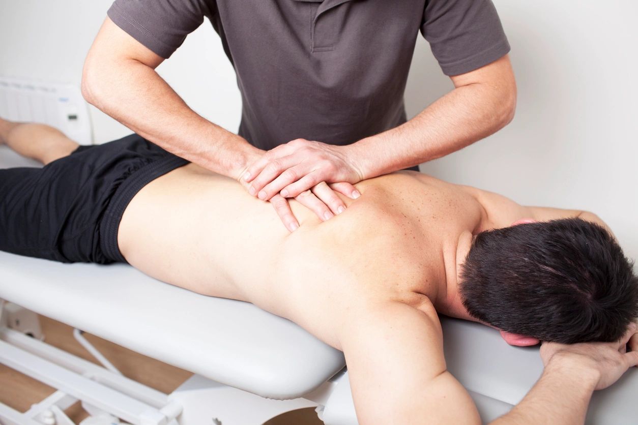 A man is getting his back examined by an osteopath.